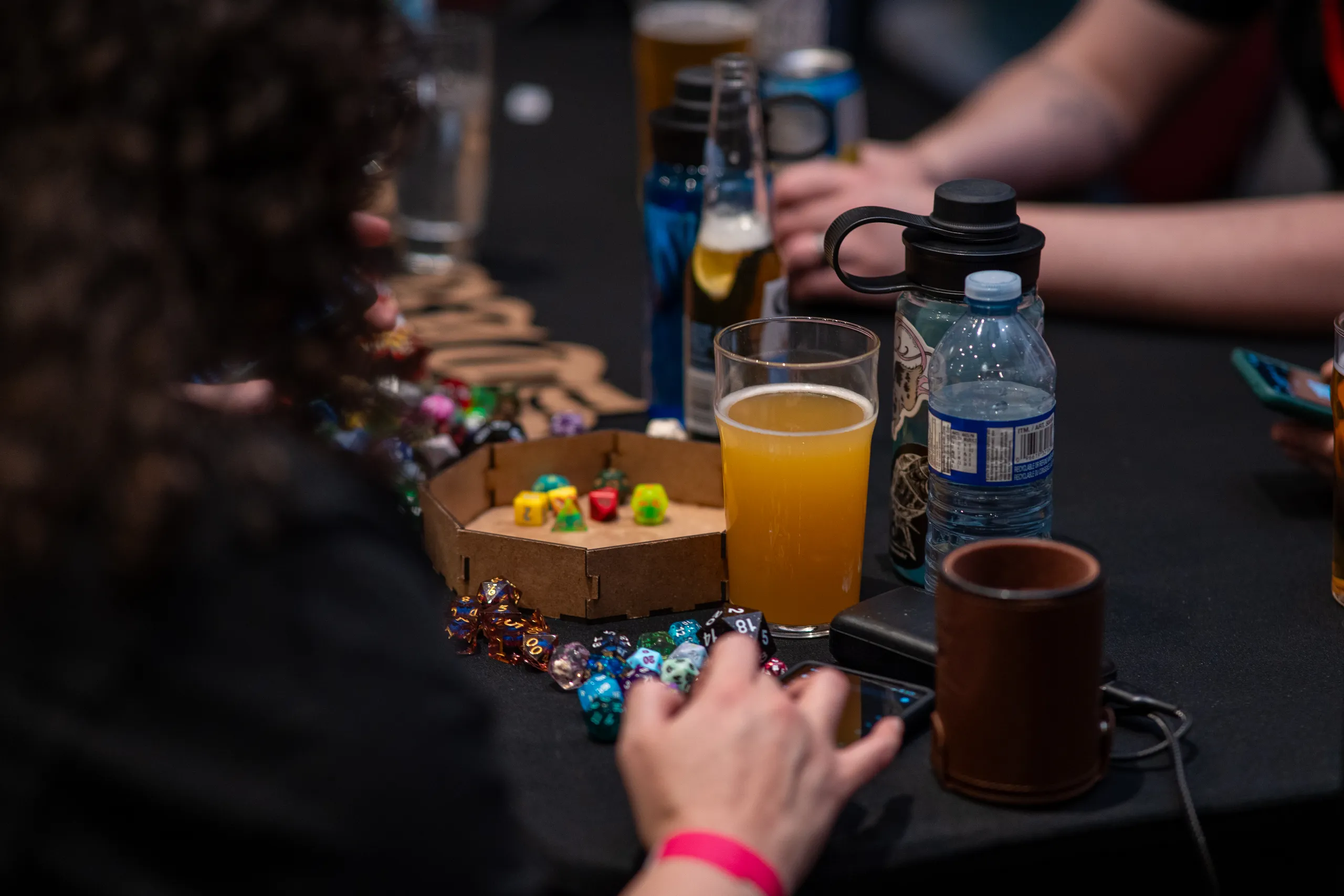 Dice, drinks, and a branded bottle laid out across the table.