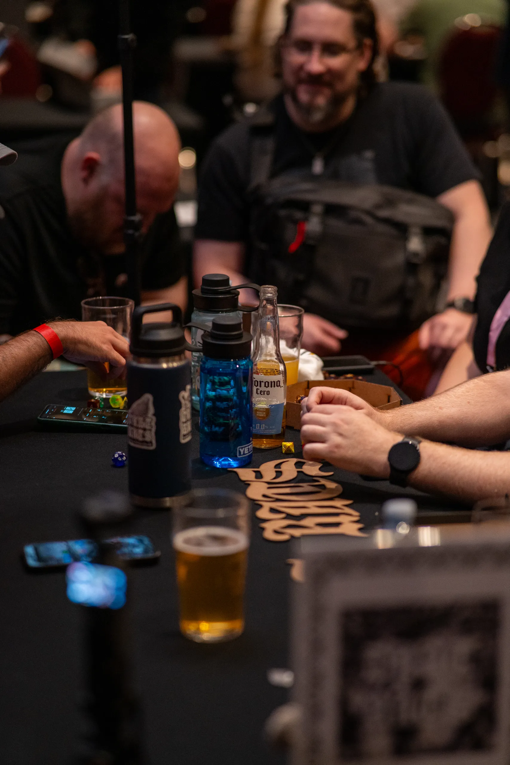 Dice, a glass, and game components on the table mid-session.
