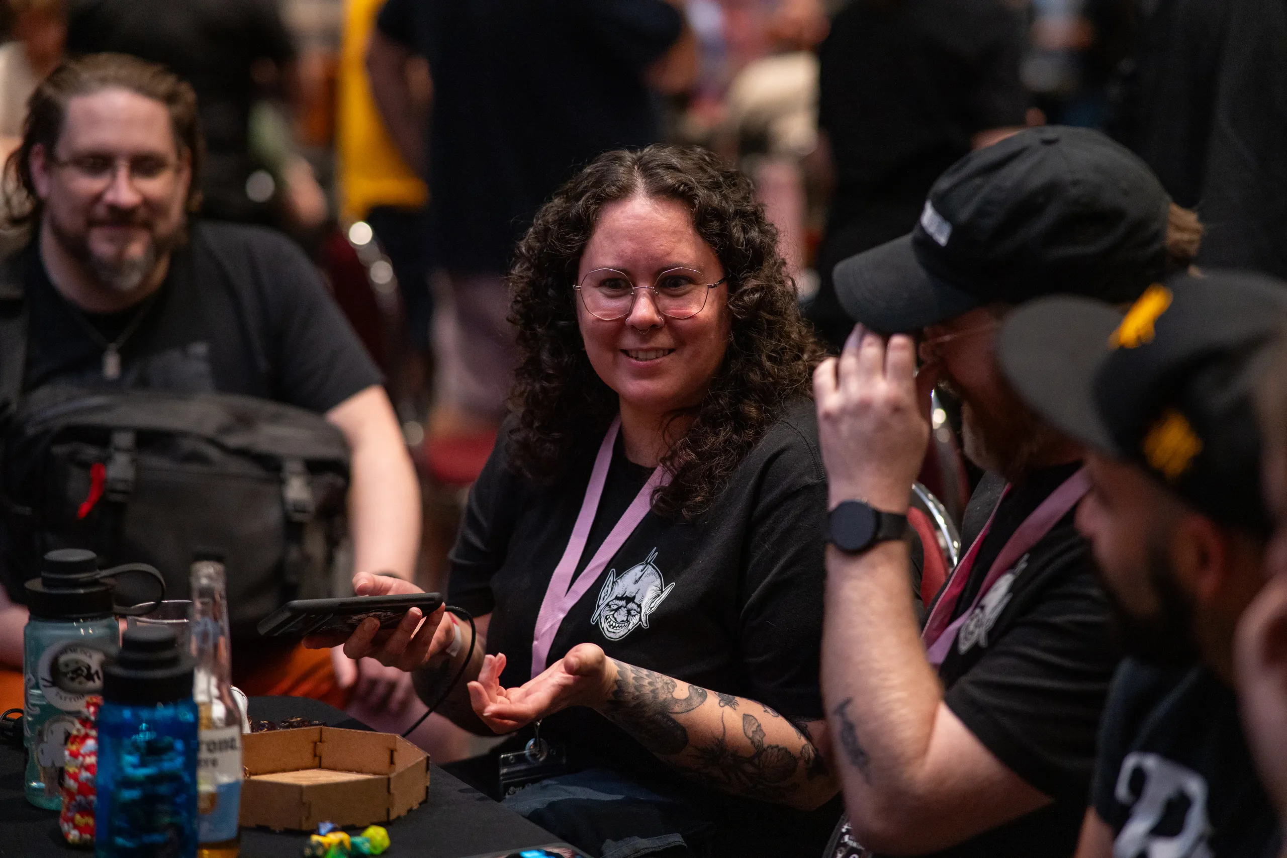 A player laughing with a phone in hand at the table.
