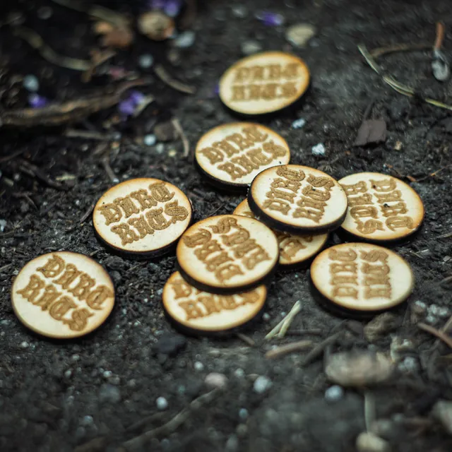 Engraved wooden bases scattered on dark soil